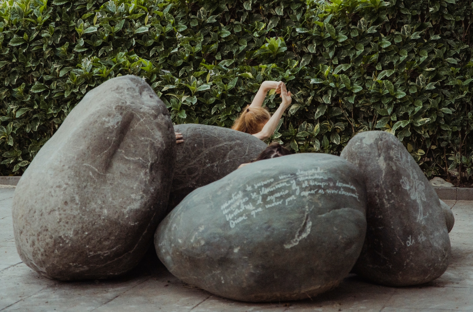 The Flower Who Came from the Stars — a dancer moves among large engraved basaltic boulders, activating the installation with choreography.
